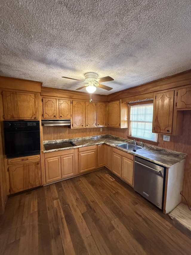 kitchen with a textured ceiling, a sink, black appliances, under cabinet range hood, and dark wood-type flooring