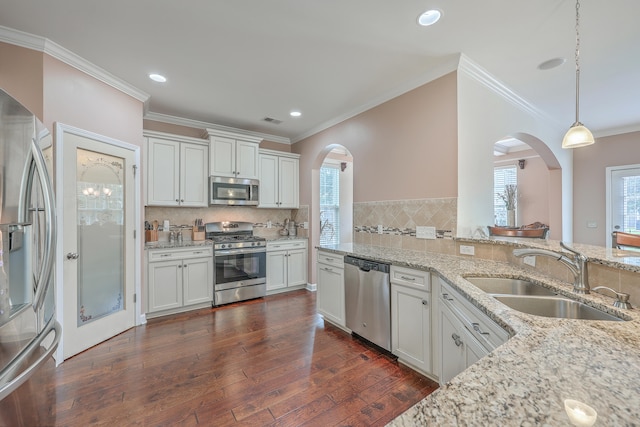 kitchen featuring sink, decorative light fixtures, white cabinetry, stainless steel appliances, and dark hardwood / wood-style flooring