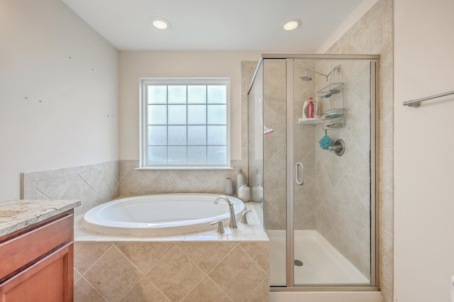 bathroom featuring shower with separate bathtub and vanity