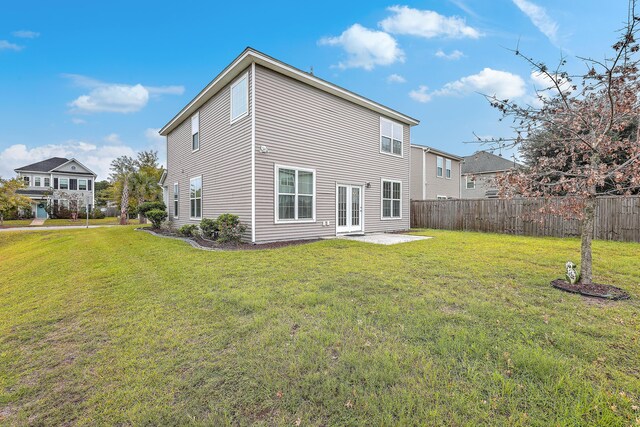 back of house featuring a lawn and a patio