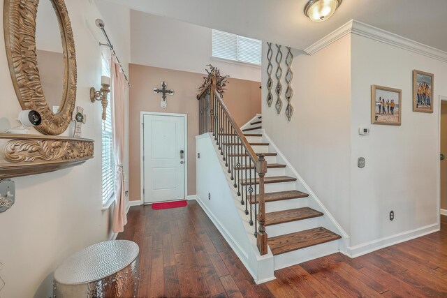 entrance foyer featuring crown molding and dark hardwood / wood-style flooring