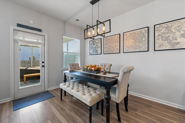 dining space featuring dark hardwood / wood-style floors and a notable chandelier