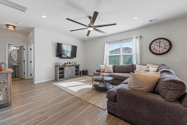 living room featuring ceiling fan and light wood-type flooring