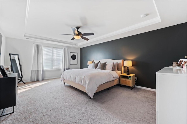 bedroom featuring ornamental molding, light colored carpet, a raised ceiling, and ceiling fan