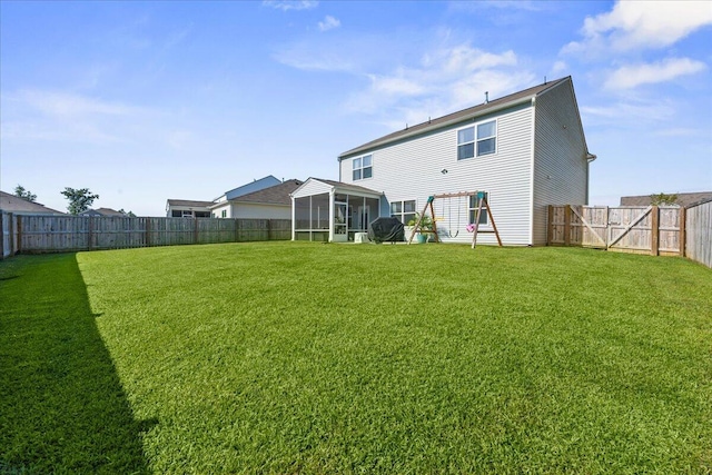 rear view of house with a yard and a sunroom