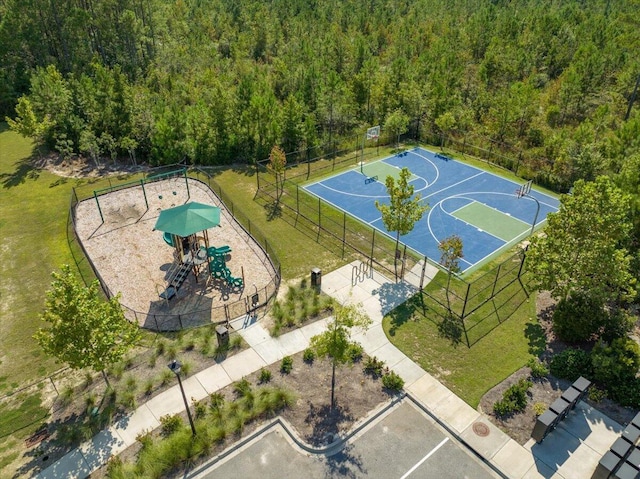 view of sport court with a playground and a lawn