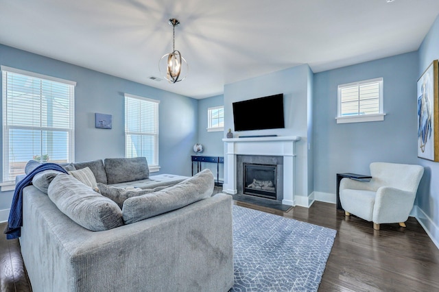 living area featuring dark wood-style floors, visible vents, plenty of natural light, and baseboards