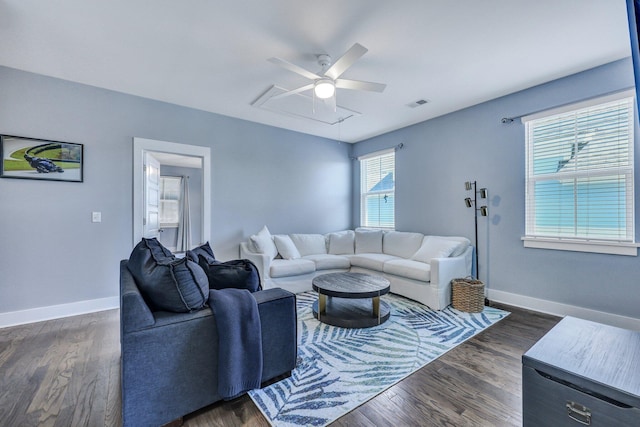 living area featuring visible vents, baseboards, dark wood-type flooring, and a ceiling fan