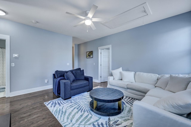 living area featuring baseboards, attic access, wood finished floors, and a ceiling fan