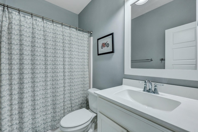 bathroom with curtained shower, toilet, and vanity