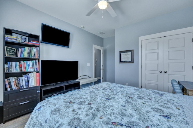 bedroom with a closet, wood finished floors, and a ceiling fan