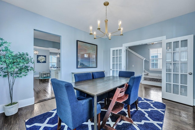 dining area with a chandelier, stairway, a wealth of natural light, and wood finished floors