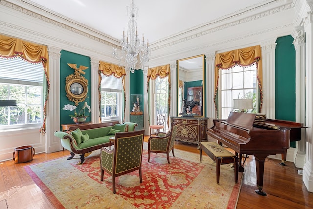 sitting room with crown molding, hardwood / wood-style floors, and a chandelier