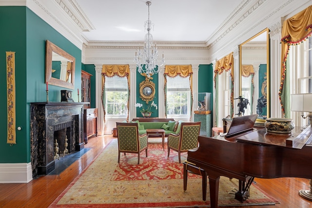 living area featuring a chandelier, a high end fireplace, crown molding, and wood-type flooring