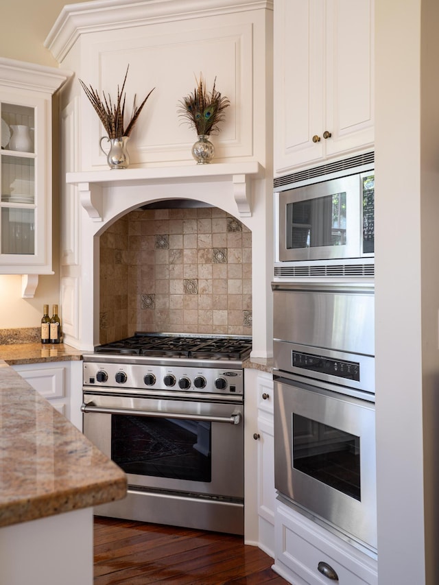 kitchen with white cabinetry, decorative backsplash, light stone countertops, and appliances with stainless steel finishes