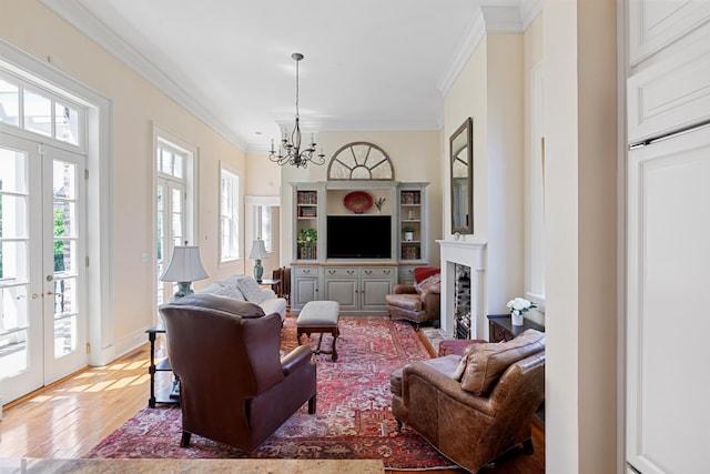 living room featuring hardwood / wood-style floors, french doors, a notable chandelier, and ornamental molding