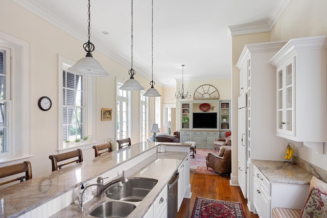 kitchen featuring light stone countertops, pendant lighting, and white cabinets