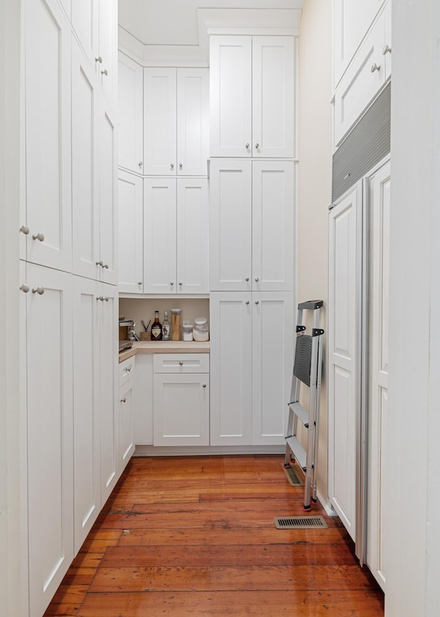 kitchen with white cabinetry and light hardwood / wood-style flooring