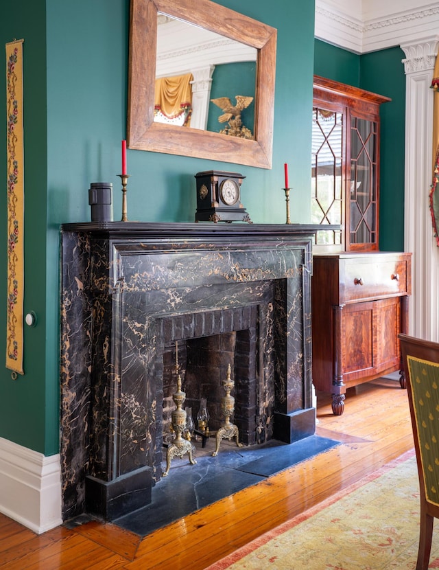 interior details with hardwood / wood-style flooring, crown molding, and ornate columns