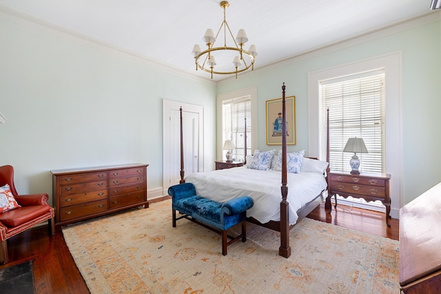 bedroom featuring a notable chandelier, hardwood / wood-style flooring, and ornamental molding