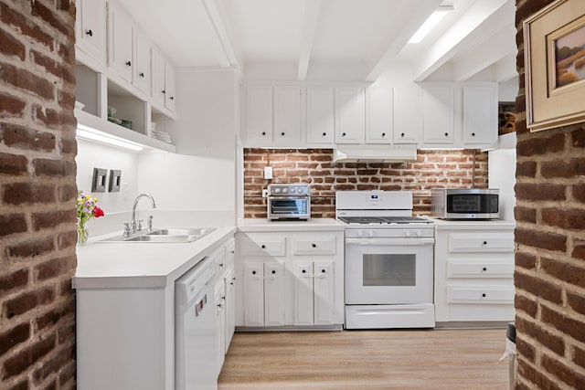 kitchen featuring sink, white cabinetry, white appliances, and brick wall