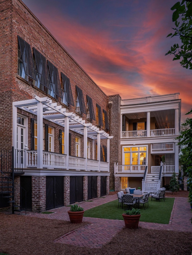 back house at dusk with an outdoor living space and a pergola