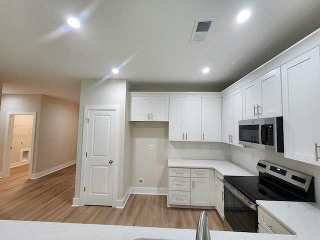 1207 Albert Storm Ave, Moncks Corner, SC 29461 - kitchen featuring stainless steel appliances, white cabinetry, light wood-type flooring, baseboards, and recessed lighting