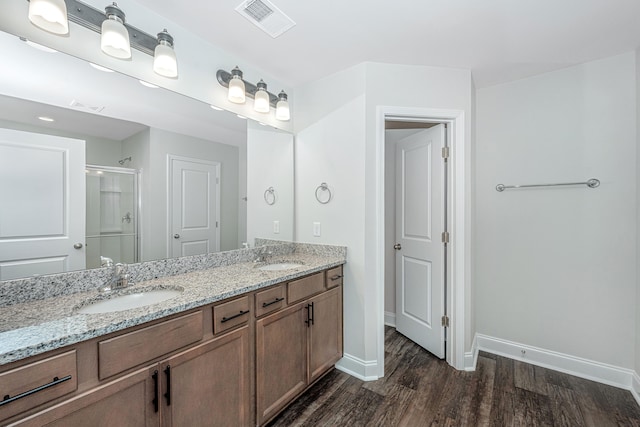 bathroom with vanity, a shower with shower door, and wood-type flooring