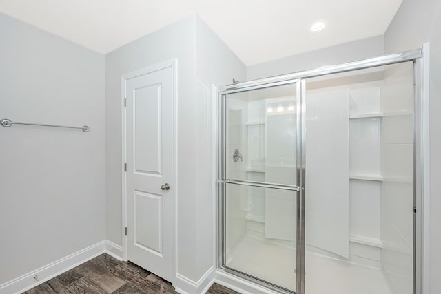 bathroom with a shower with door and hardwood / wood-style flooring