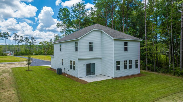 rear view of house featuring central air condition unit, a patio, and a lawn