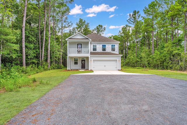 view of front of home featuring a balcony, a front yard, a garage, and a porch