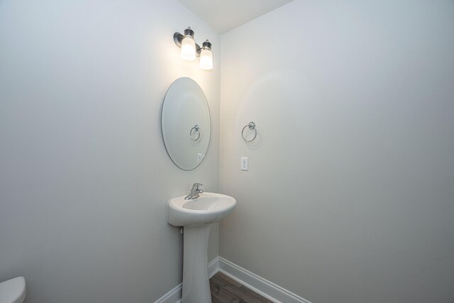 bathroom with toilet and hardwood / wood-style floors