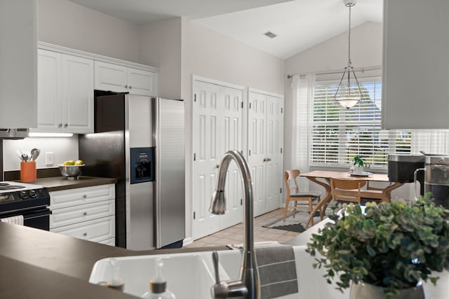 kitchen featuring stainless steel refrigerator with ice dispenser, white cabinetry, hanging light fixtures, and lofted ceiling