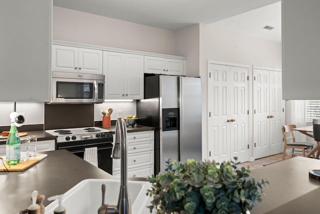 kitchen featuring white cabinets, light tile patterned floors, and stainless steel appliances