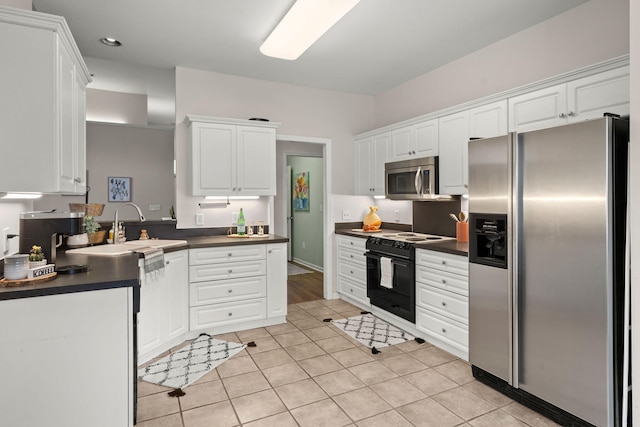 kitchen featuring sink, white cabinetry, stainless steel appliances, and light tile patterned floors