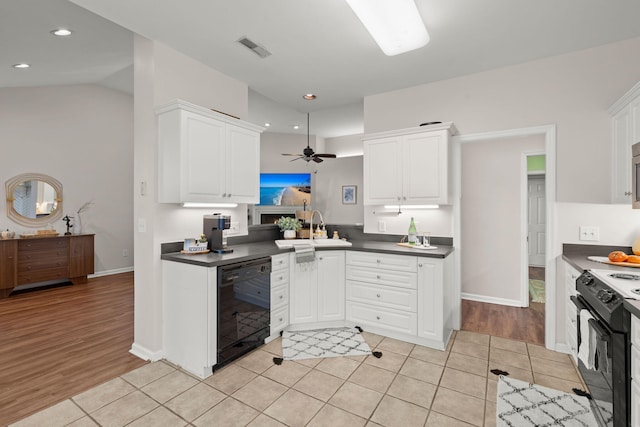 kitchen featuring sink, black appliances, lofted ceiling, and light hardwood / wood-style flooring