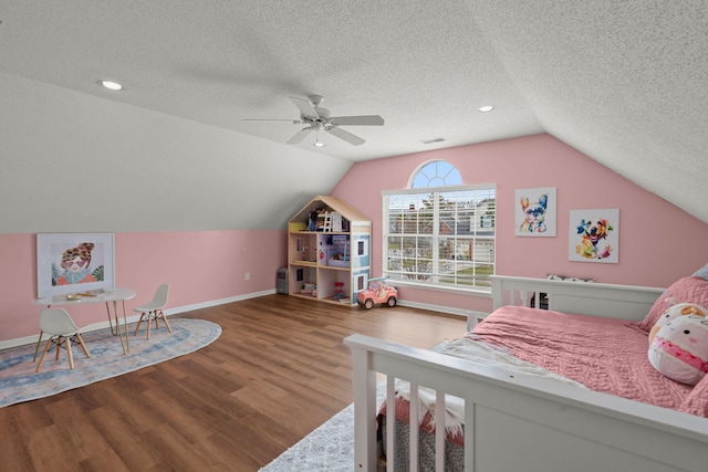 bedroom with hardwood / wood-style floors, ceiling fan, a textured ceiling, and vaulted ceiling