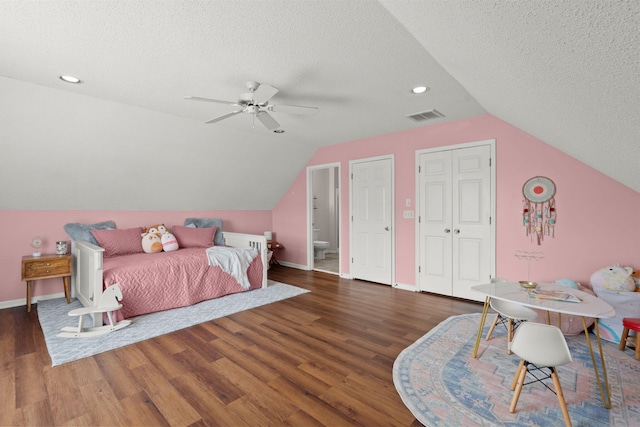 bedroom featuring a textured ceiling, dark hardwood / wood-style flooring, ceiling fan, and lofted ceiling