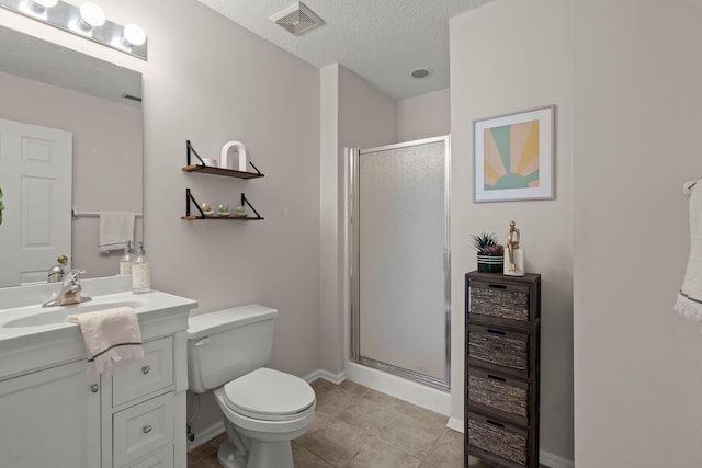 bathroom with a textured ceiling, vanity, a shower with door, tile patterned flooring, and toilet