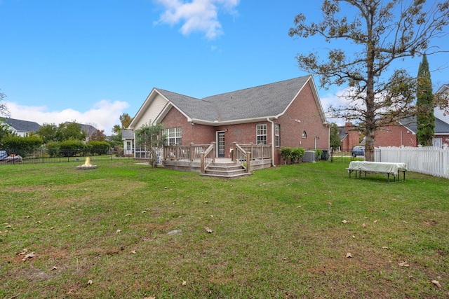 back of property featuring a deck, central AC unit, and a lawn