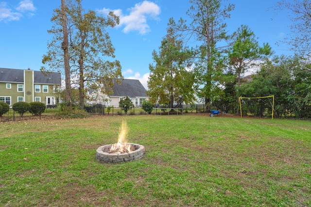 view of yard featuring a trampoline and a fire pit