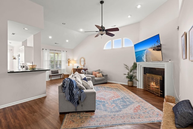 living room featuring ceiling fan, high vaulted ceiling, and dark hardwood / wood-style floors