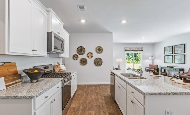 kitchen featuring appliances with stainless steel finishes, sink, light stone counters, dark hardwood / wood-style flooring, and white cabinets