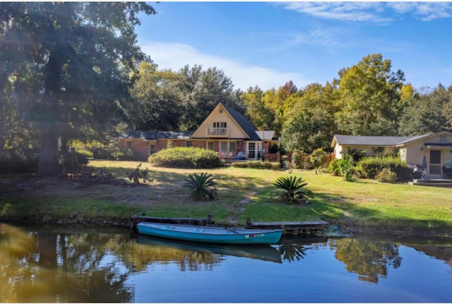 rear view of property featuring a yard and a water view