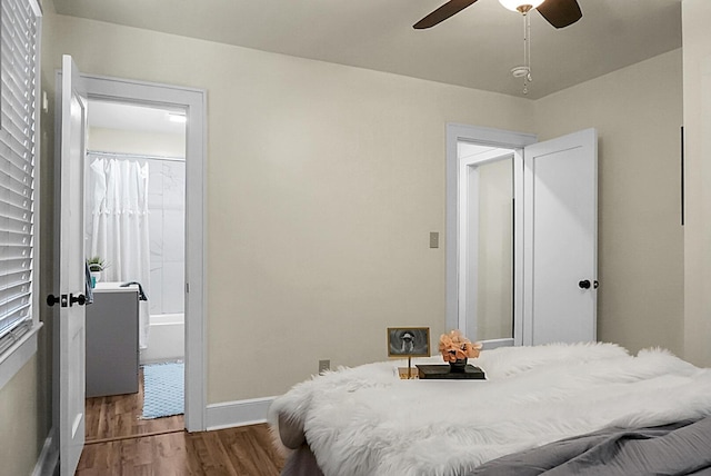 bedroom featuring wood finished floors, baseboards, connected bathroom, and a ceiling fan