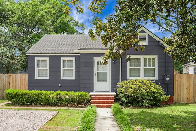 bungalow-style home with roof with shingles