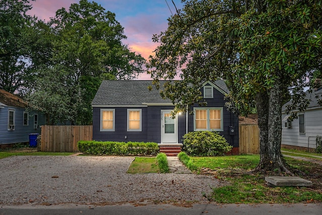 view of front of property with fence and a shingled roof