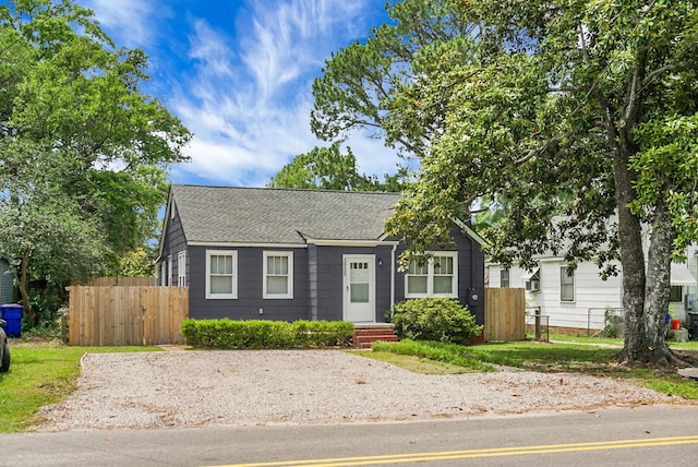 view of front of house with fence and roof with shingles