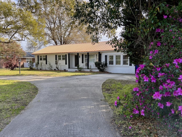 1329 Camp Rd, Charleston, SC 29412 - single story home with a porch, asphalt driveway, metal roof, and a front lawn