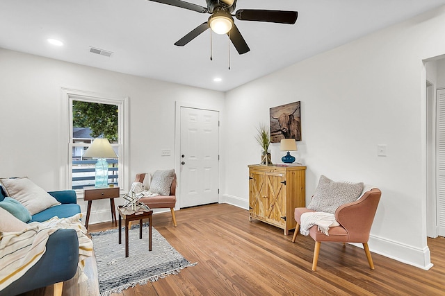 sitting room with hardwood / wood-style floors and ceiling fan